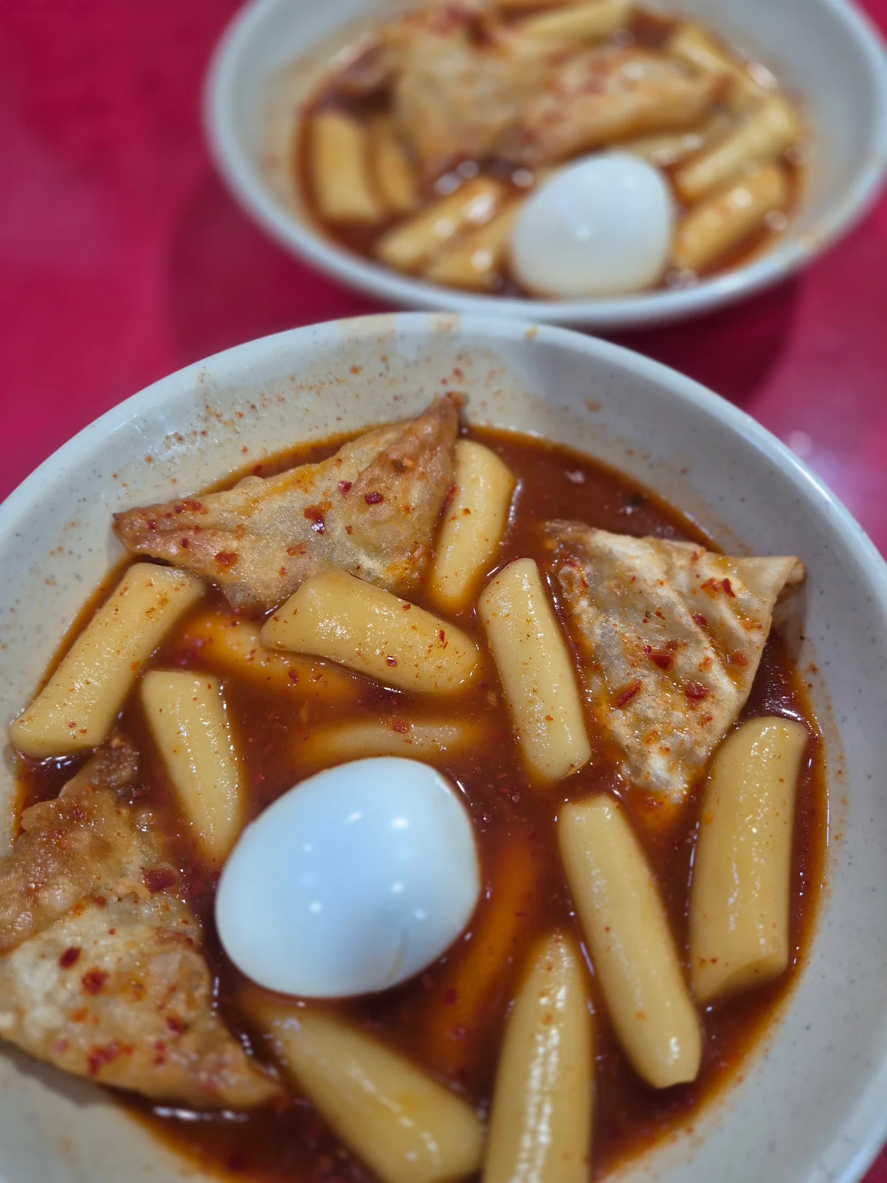새하얀 찐계란이 정중앙에 올라간 달고떡볶이 한 그릇의 아름다운 푸드 포커싱 사진