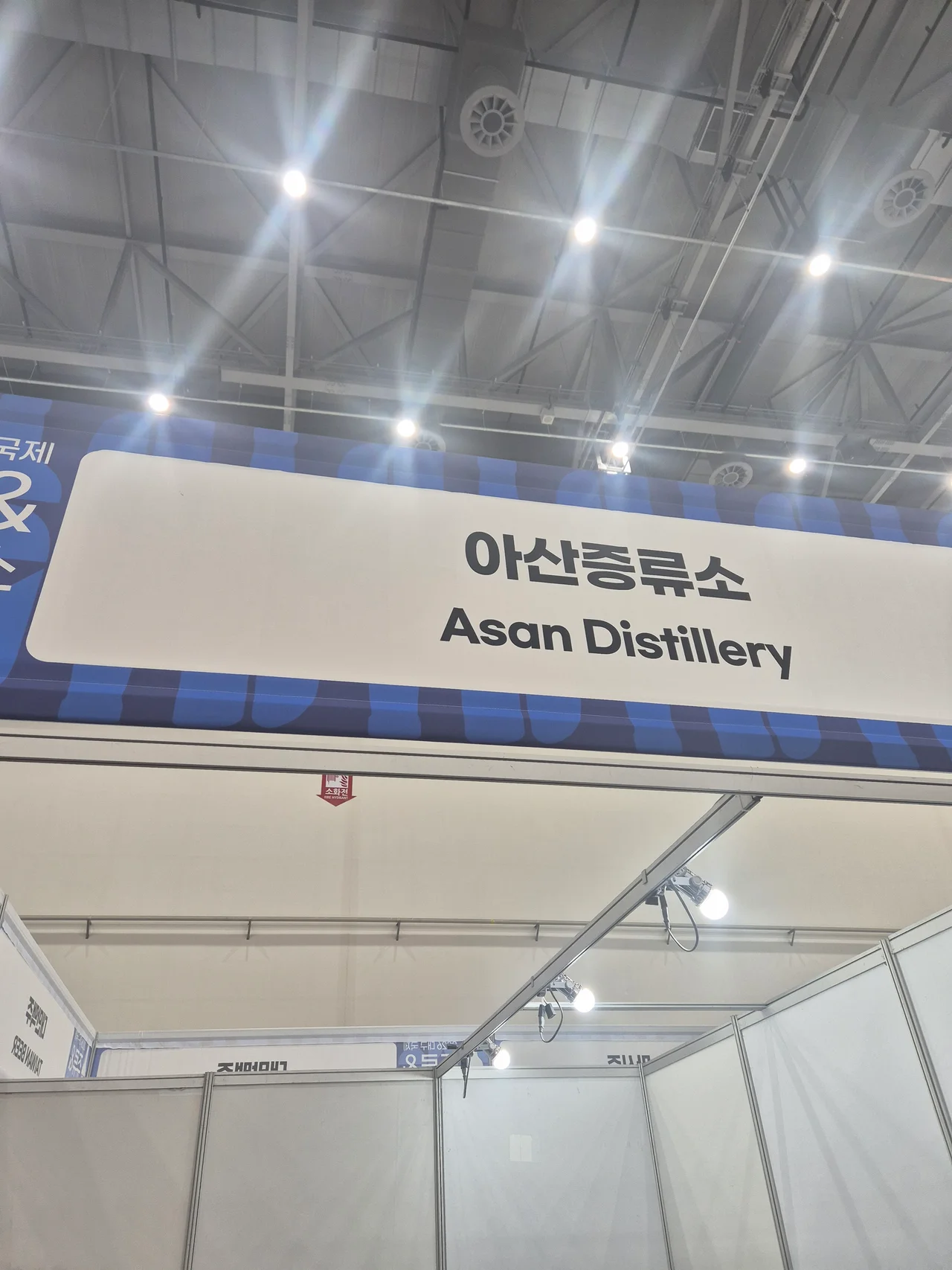 심플하고 모던한 화이트와 네이비 색 조합의 아산증류소 브랜드 현수막