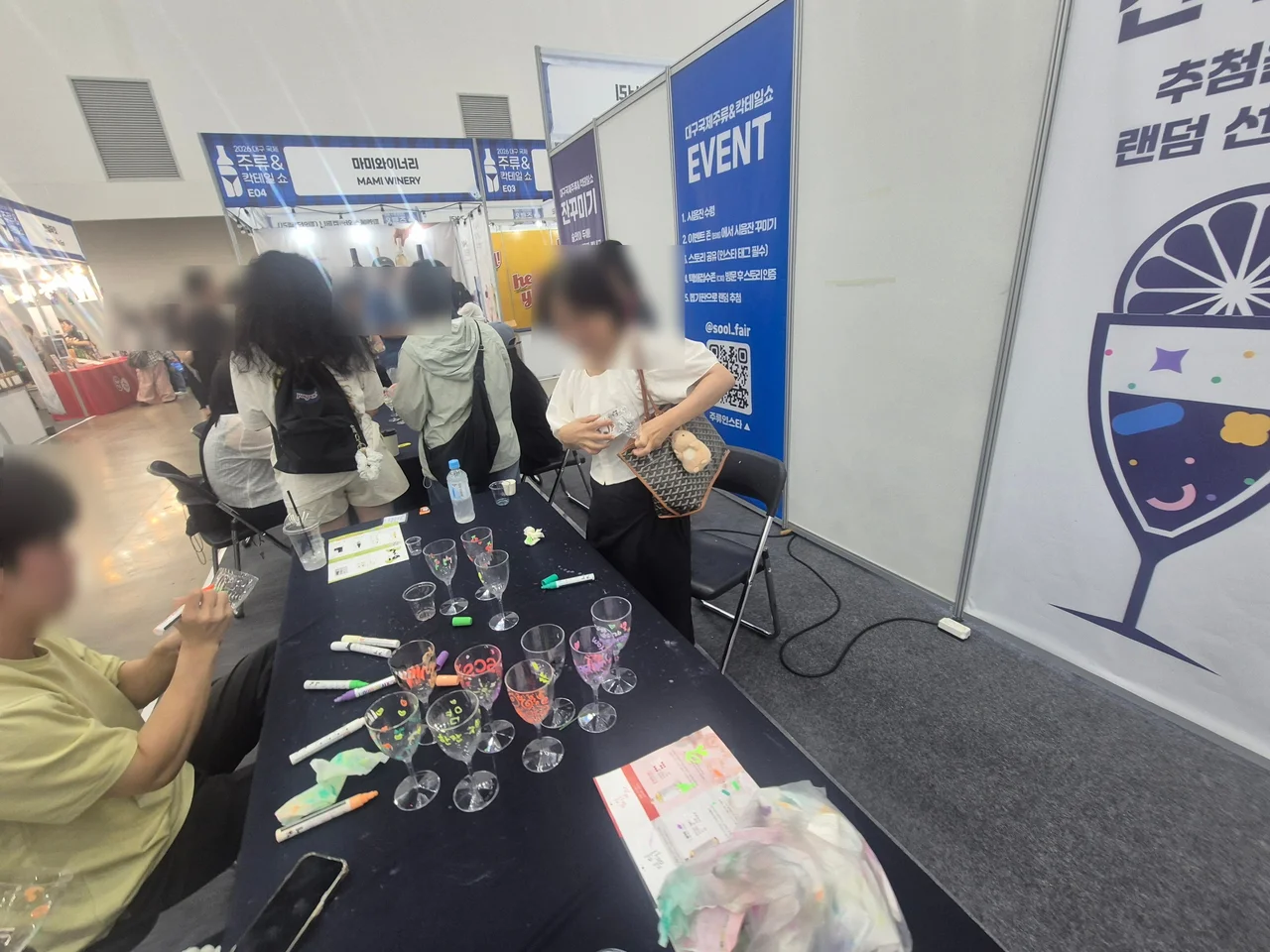 다채로운 마커로 와인잔 꾸미기에 몰두하고 있는 관람객들