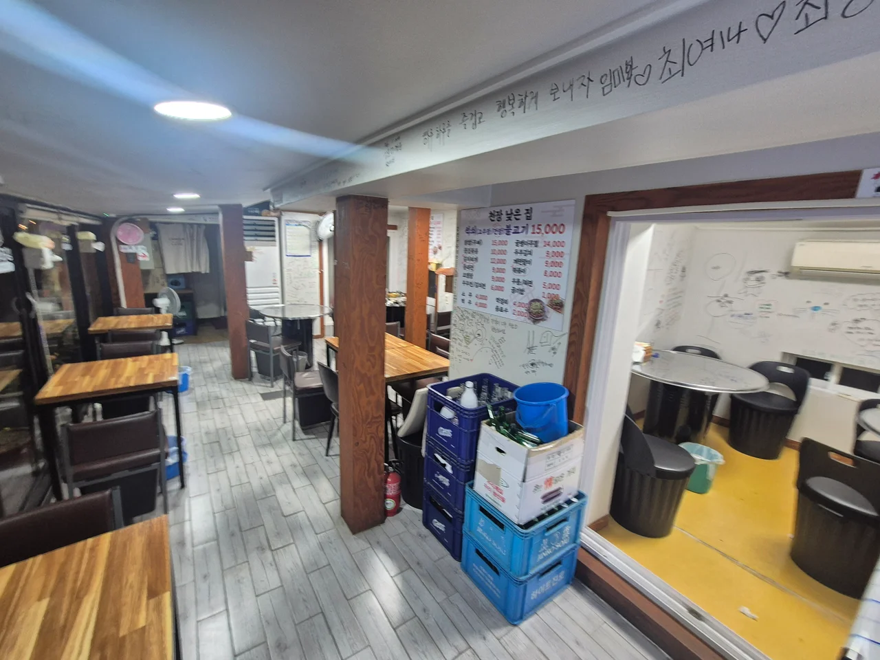 나무 기둥과 천장에 손님들의 손글씨 낙서가 가득 적힌 천장낮은집 내부 홀 좌석