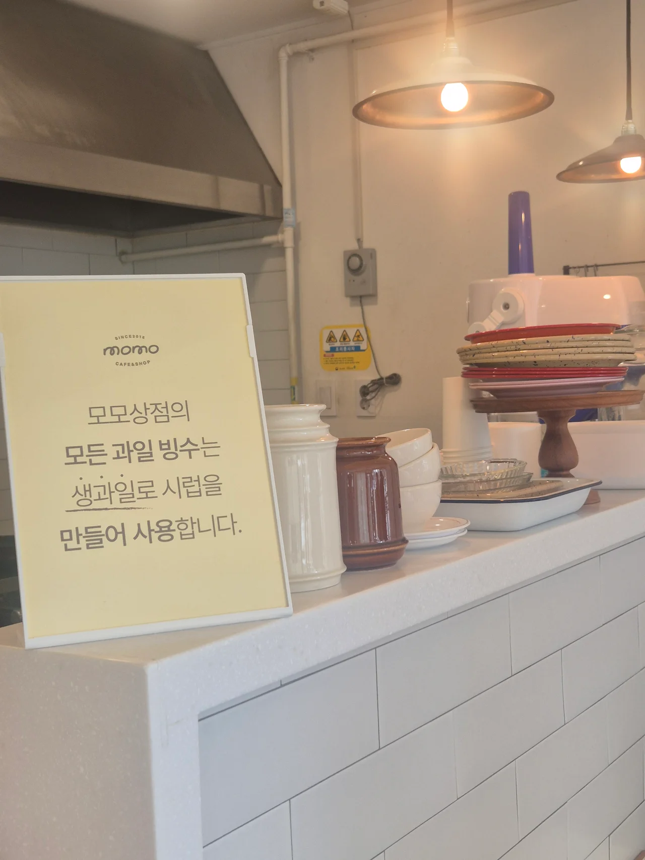생과일 시럽 사용 안내 문구가 적힌 노란색 안내판