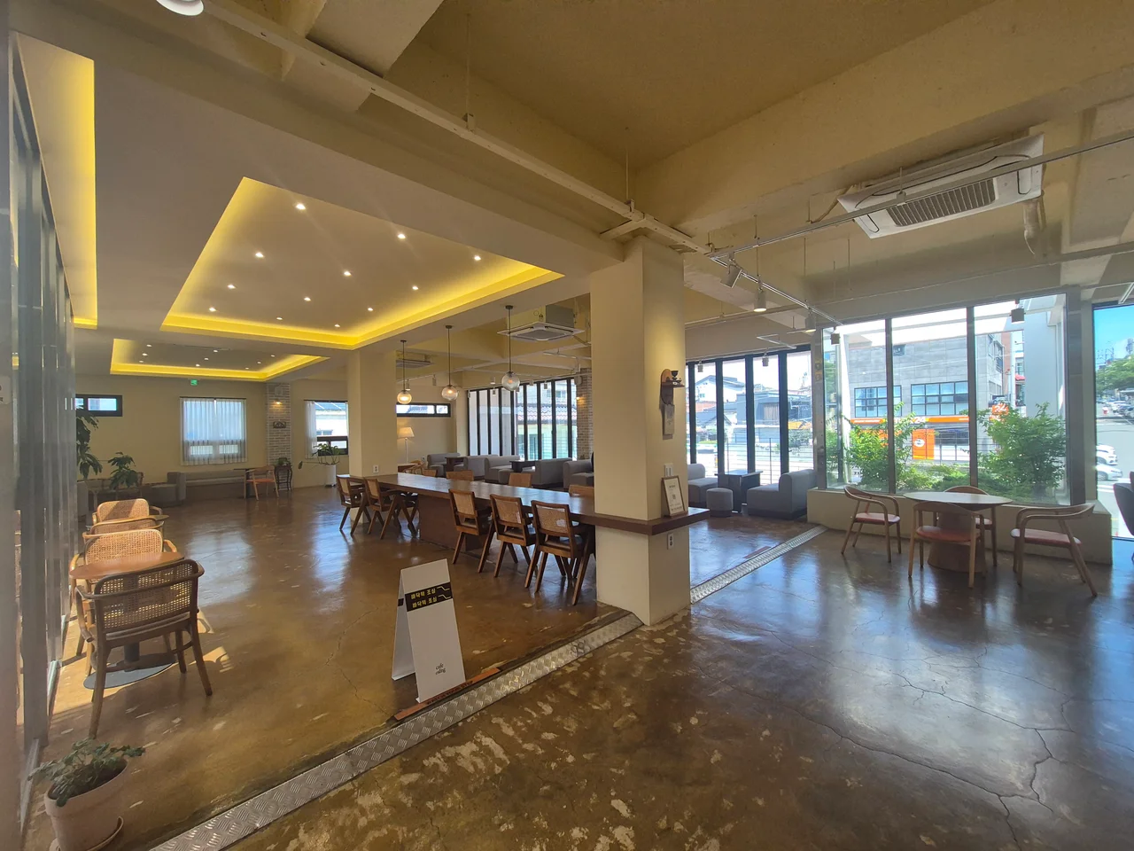 긴 원목 테이블이 놓인 단체석과 전체적인 매장 전경