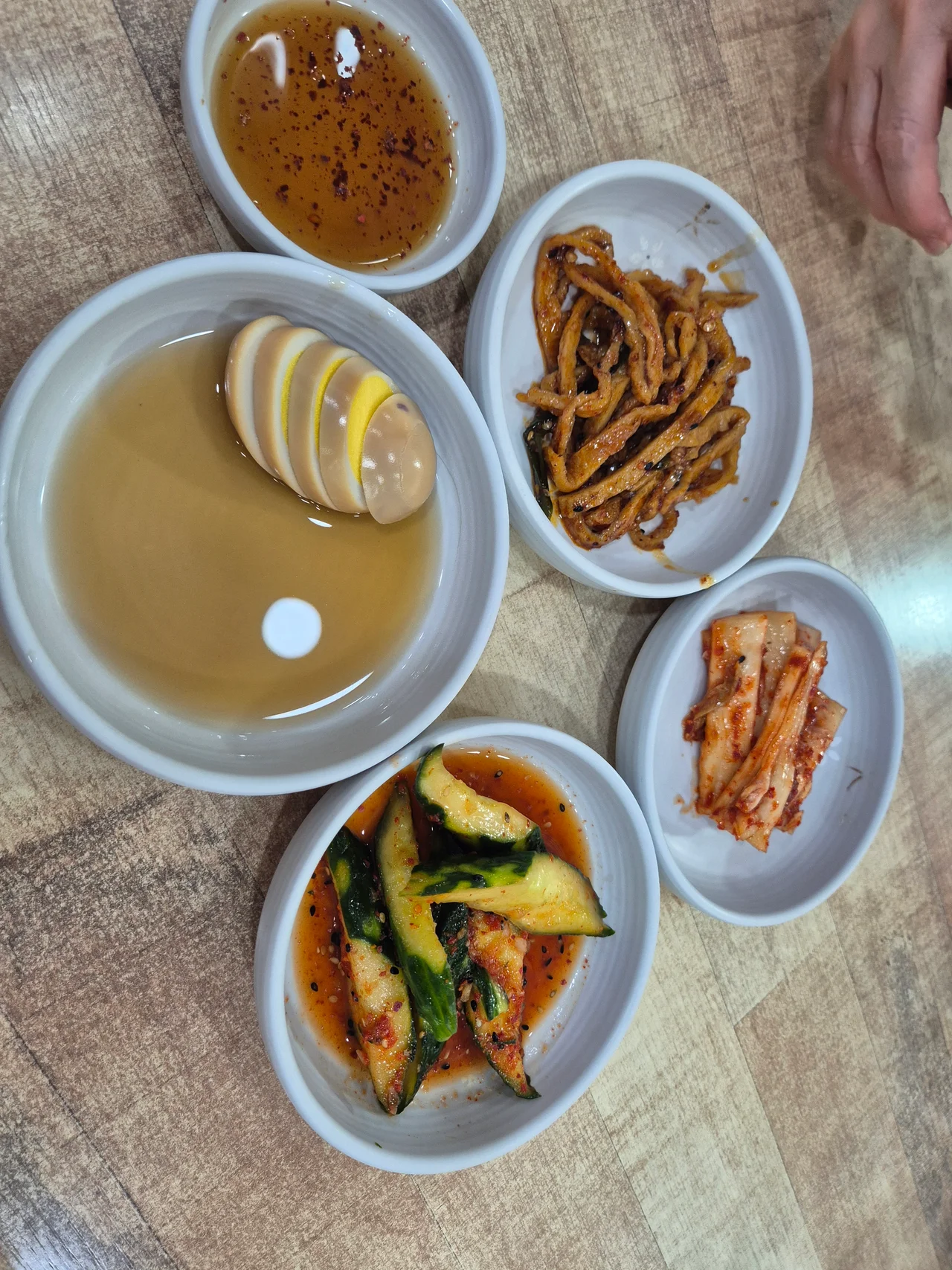 계란장조림, 어묵볶음, 오이무침, 김치가 담긴 깔끔한 기본 반찬