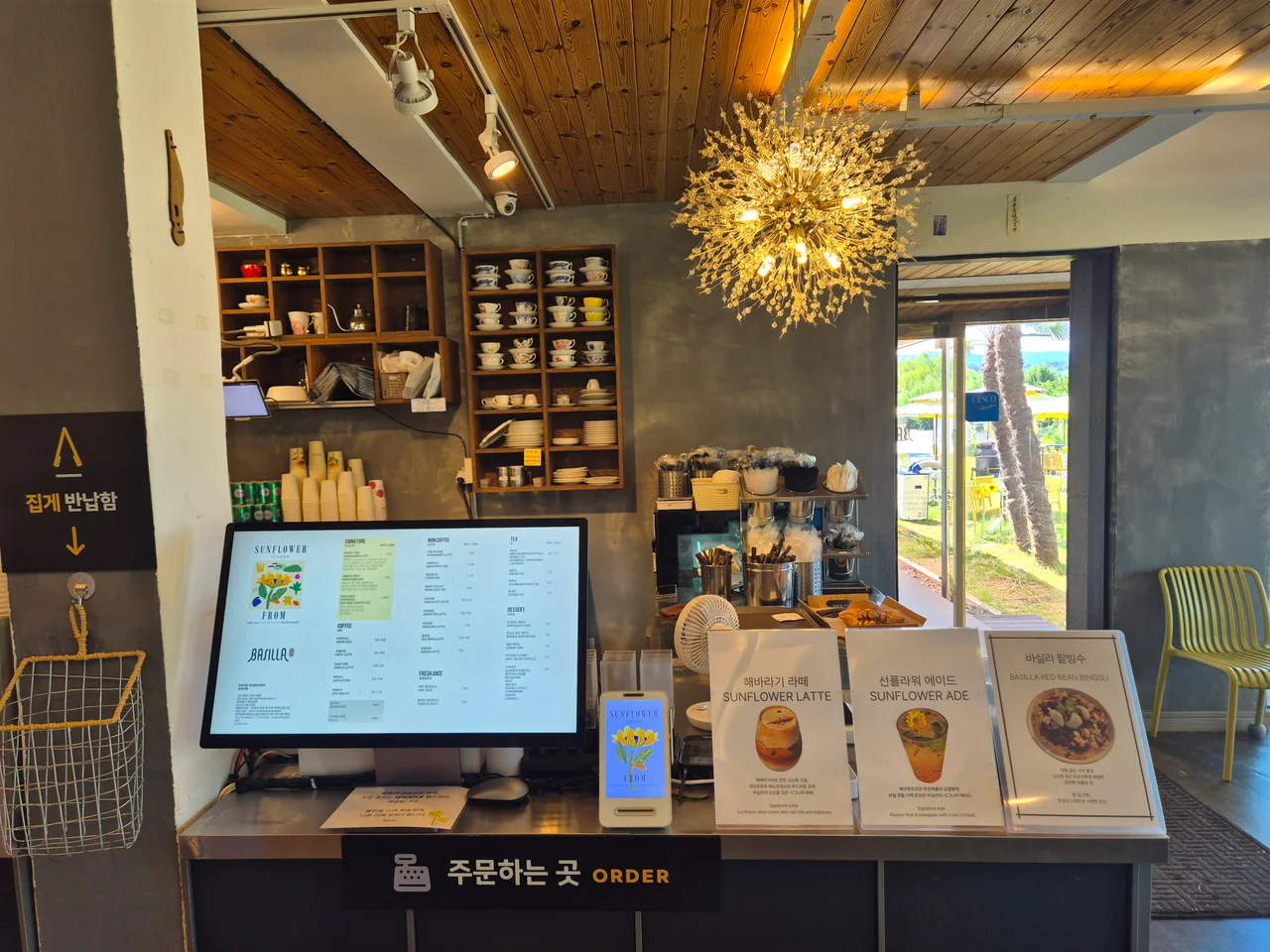 키오스크와 시그니처 메뉴 안내판이 놓인 주문 카운터