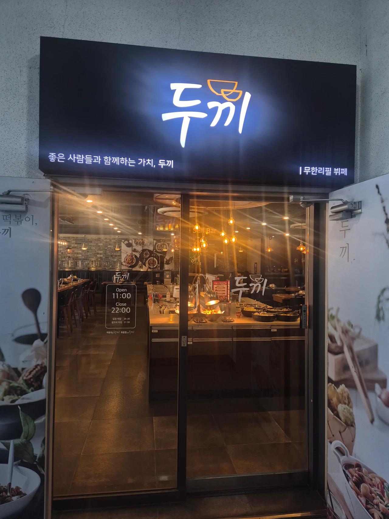 영업시간과 셀프바 마감시간 안내 문구가 적힌 두끼 매장 출입문 사진