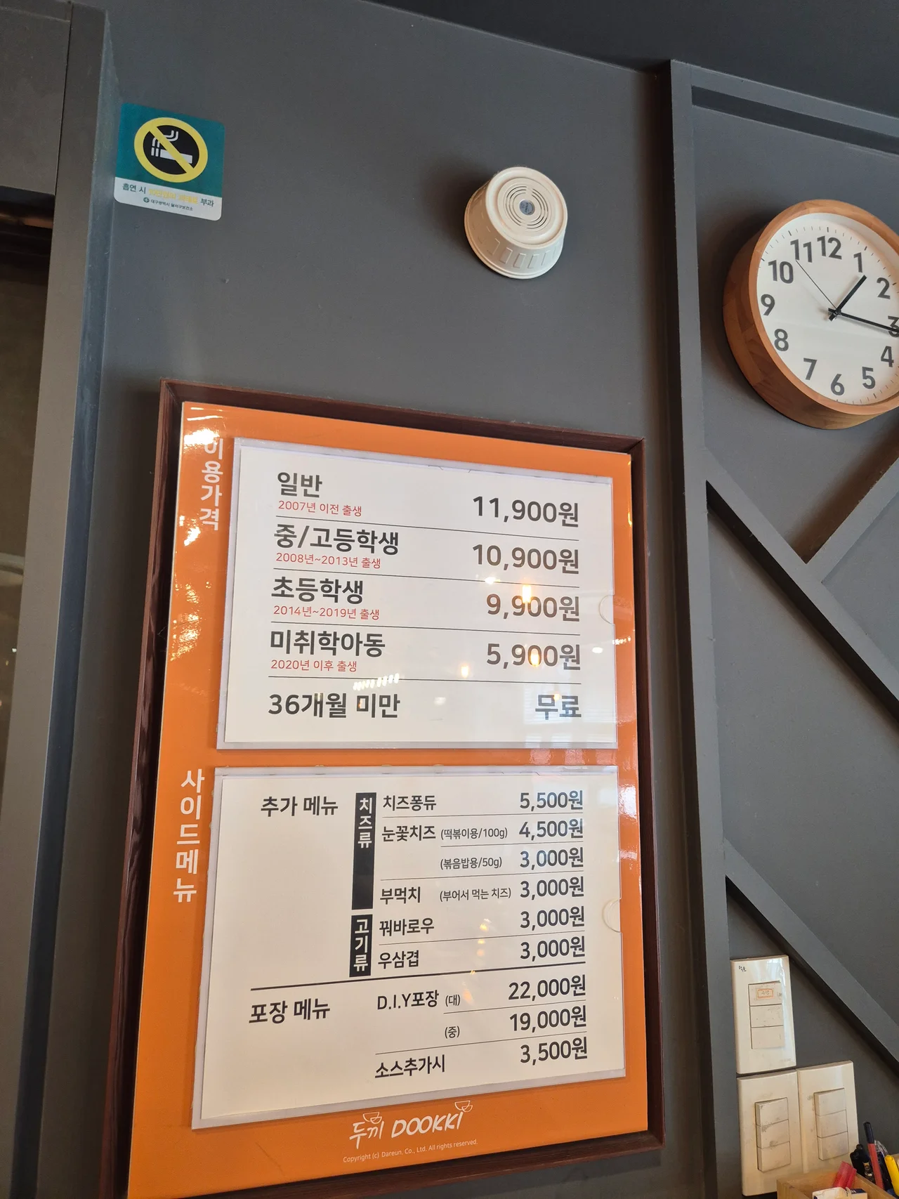 성인 및 학생 연령별 이용 가격표와 추가 사이드 메뉴 안내판 사진