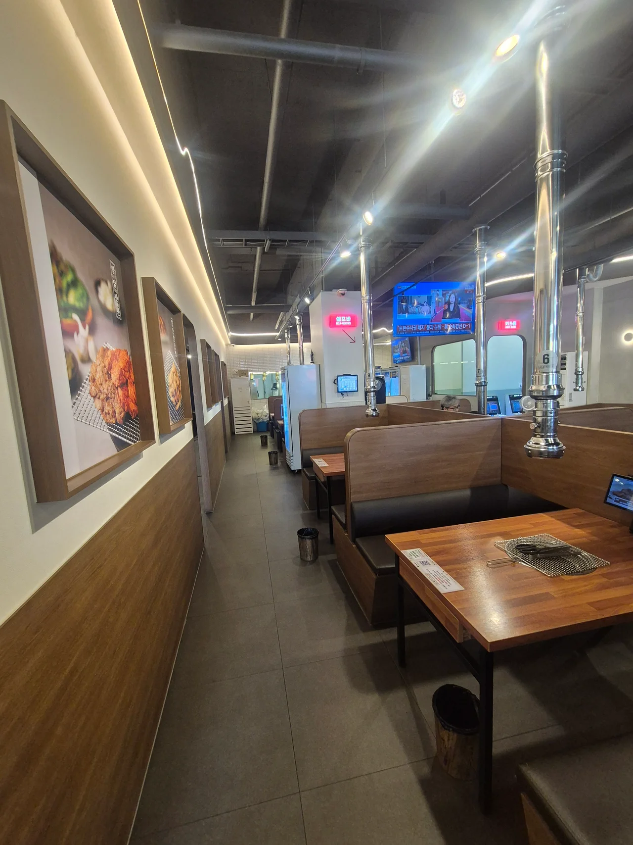 매장 내부 이동 통로와 벽면에 걸린 음식 사진 액자