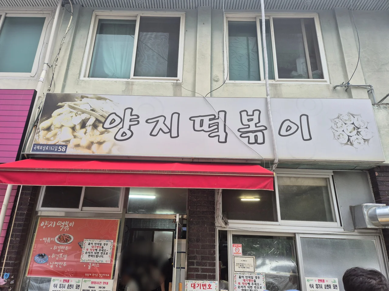 양지떡볶이 매장 간판 및 대기 안내문이 부착된 입구