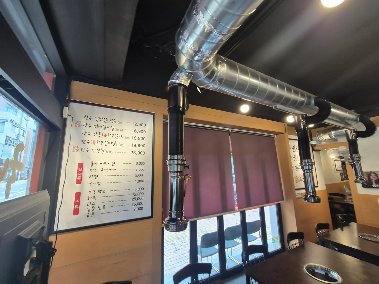 한우 메뉴와 식사류 가격이 적힌 벽면 메뉴판