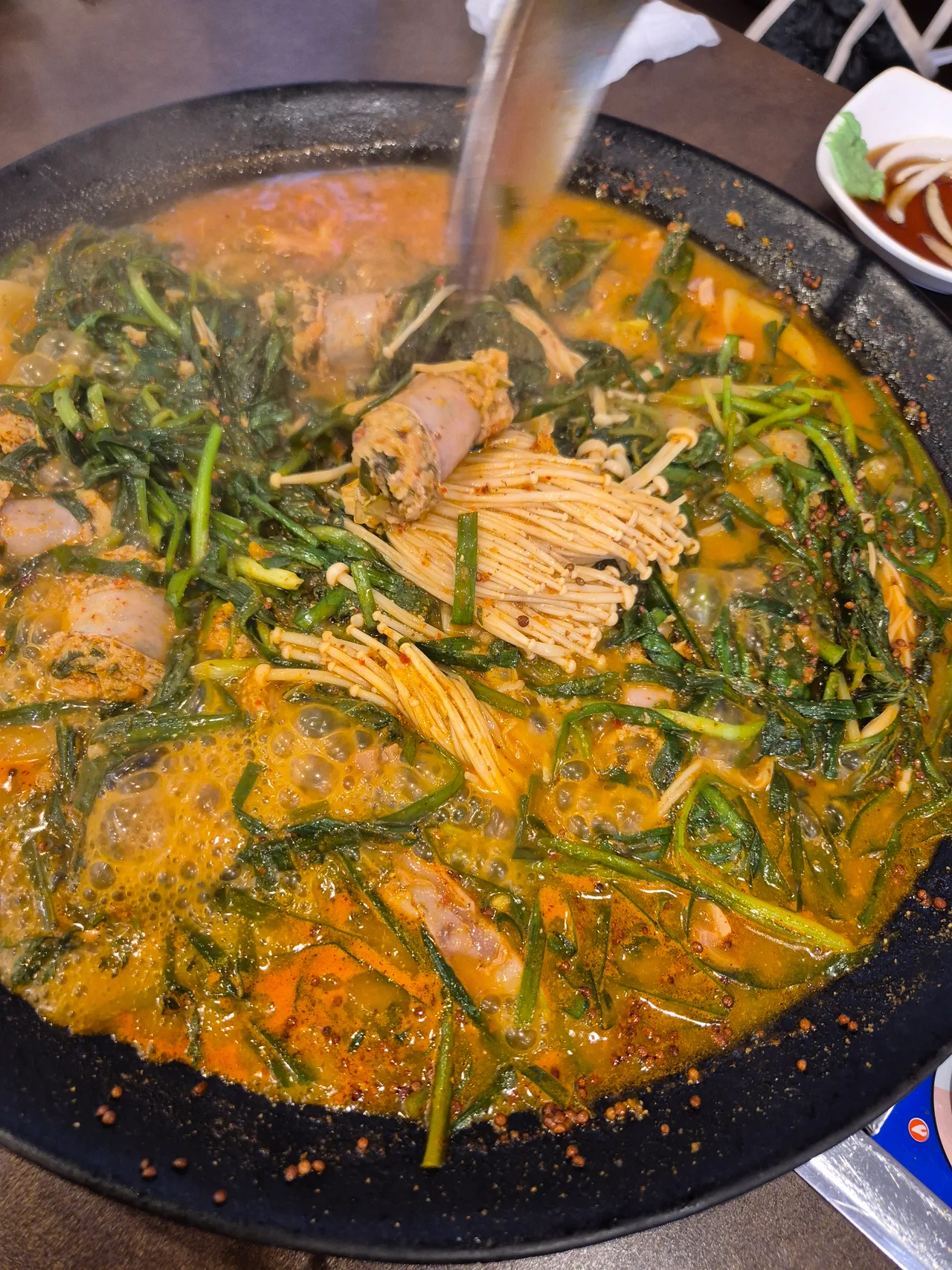 붉은 양념 국물에서 자작하게 끓어오르는 순대와 야채 전골