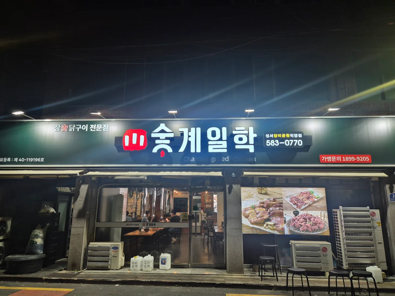 어두운 밤에 환하게 불을 밝힌 숯계일학 성서장미공원직영점 외관 전경