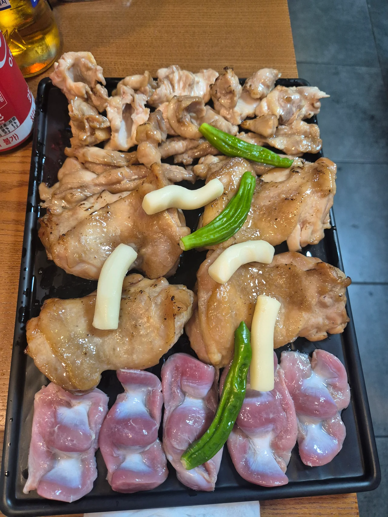 초벌구이된 닭고기와 꽈리고추 떡사리, 생 근위가 한 판에 담긴 모습