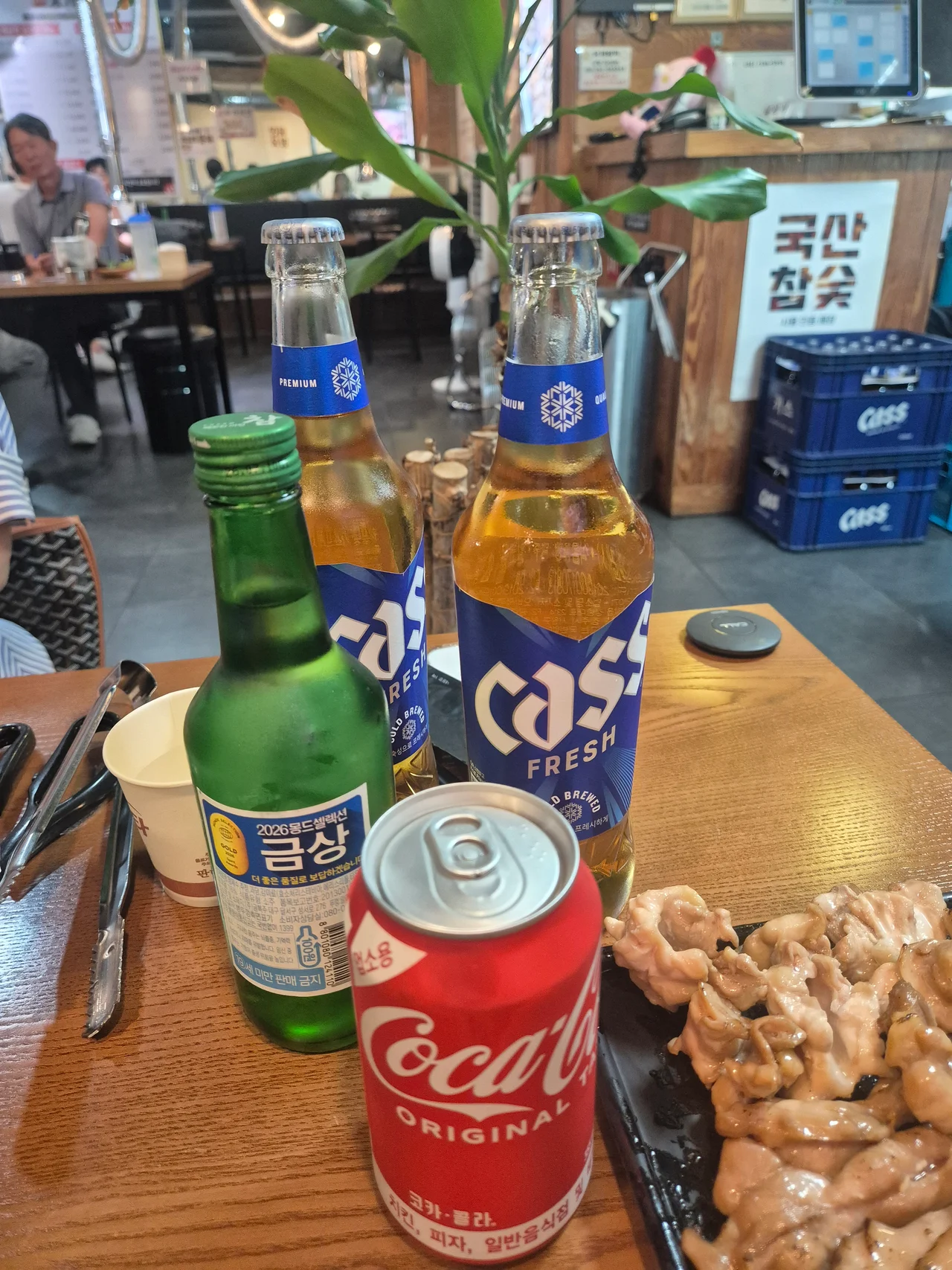 테이블에 놓인 병맥주와 소주 콜라 캔 음료