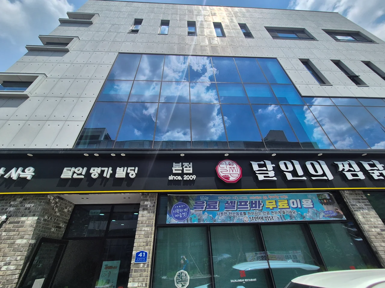 음료 셀프바 무료 이용 현수막이 붙은 달인의찜닭 매장 전면