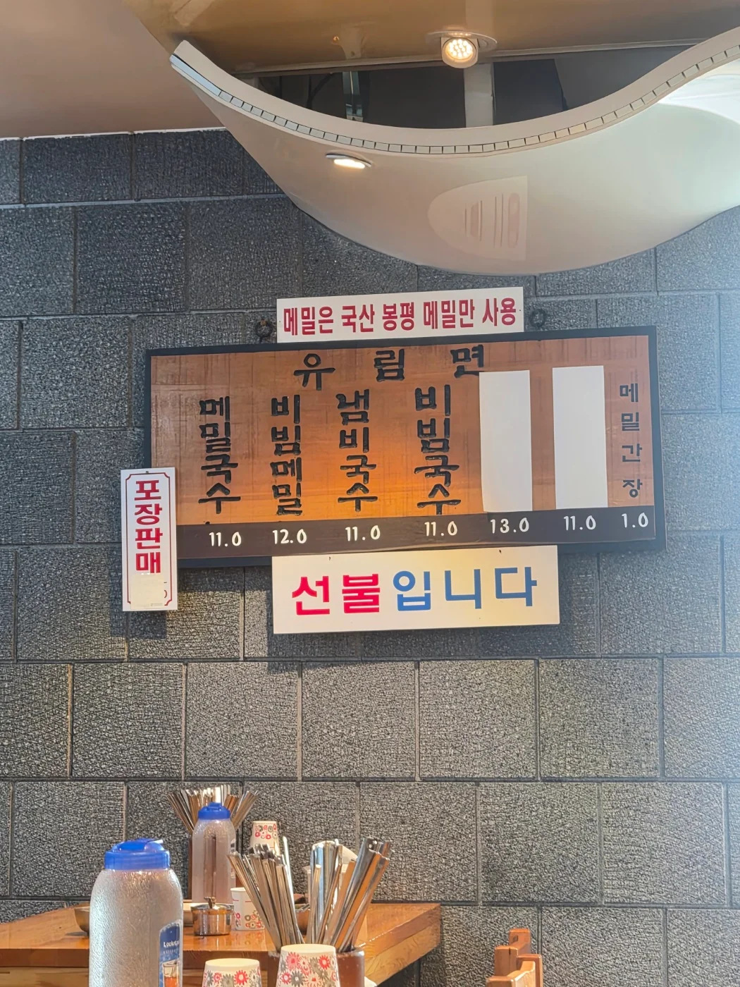 국산 봉평 메밀 사용 안내와 가격이 적힌 유림면 벽면 메뉴판