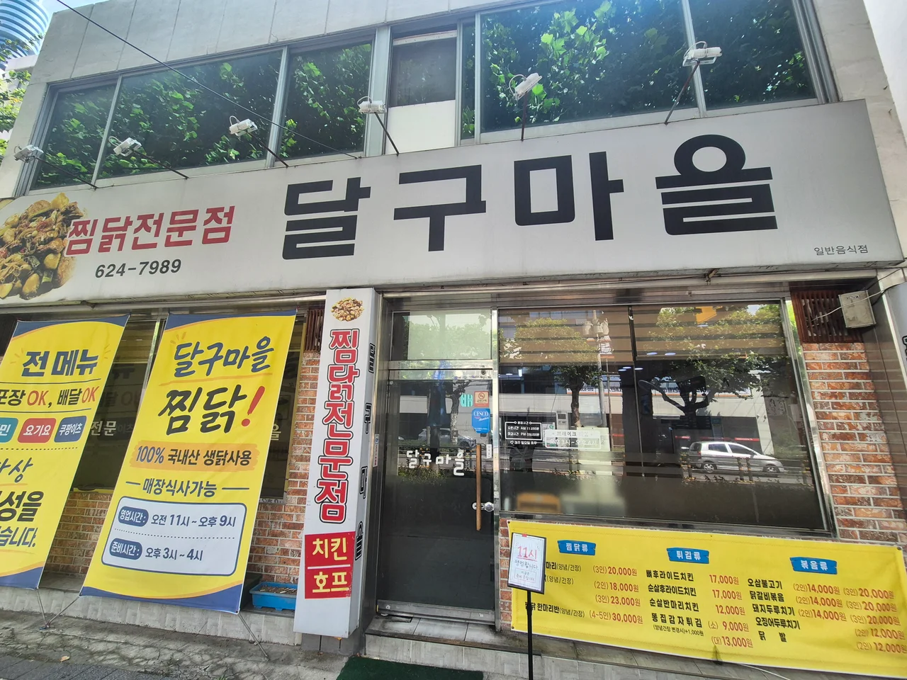 달구마을 찜닭전문점 간판과 노란색 안내 현수막이 걸린 가게 외관
