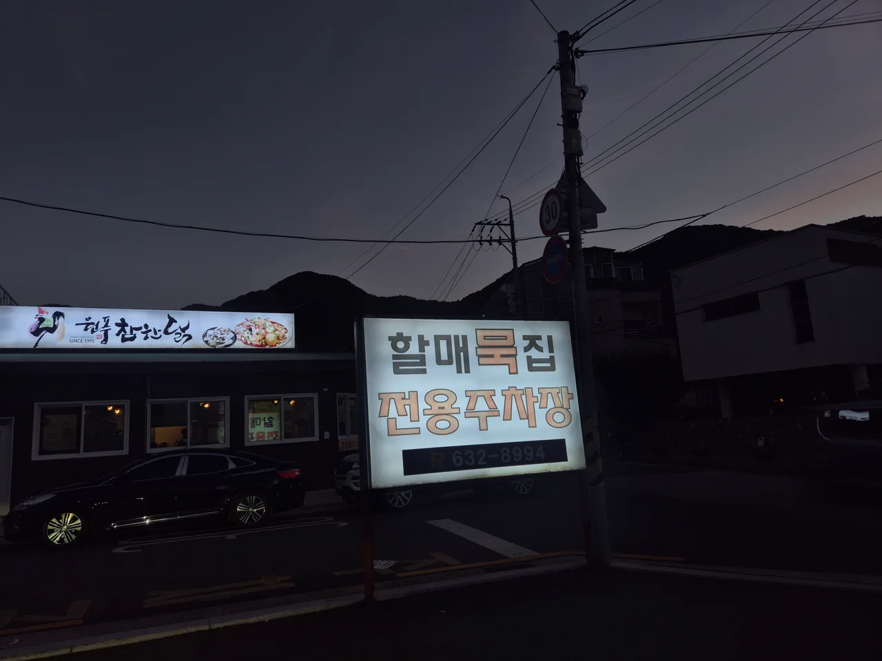 할매묵집 전용주차장 안내 표지판이 서 있는 어스름한 저녁 풍경
