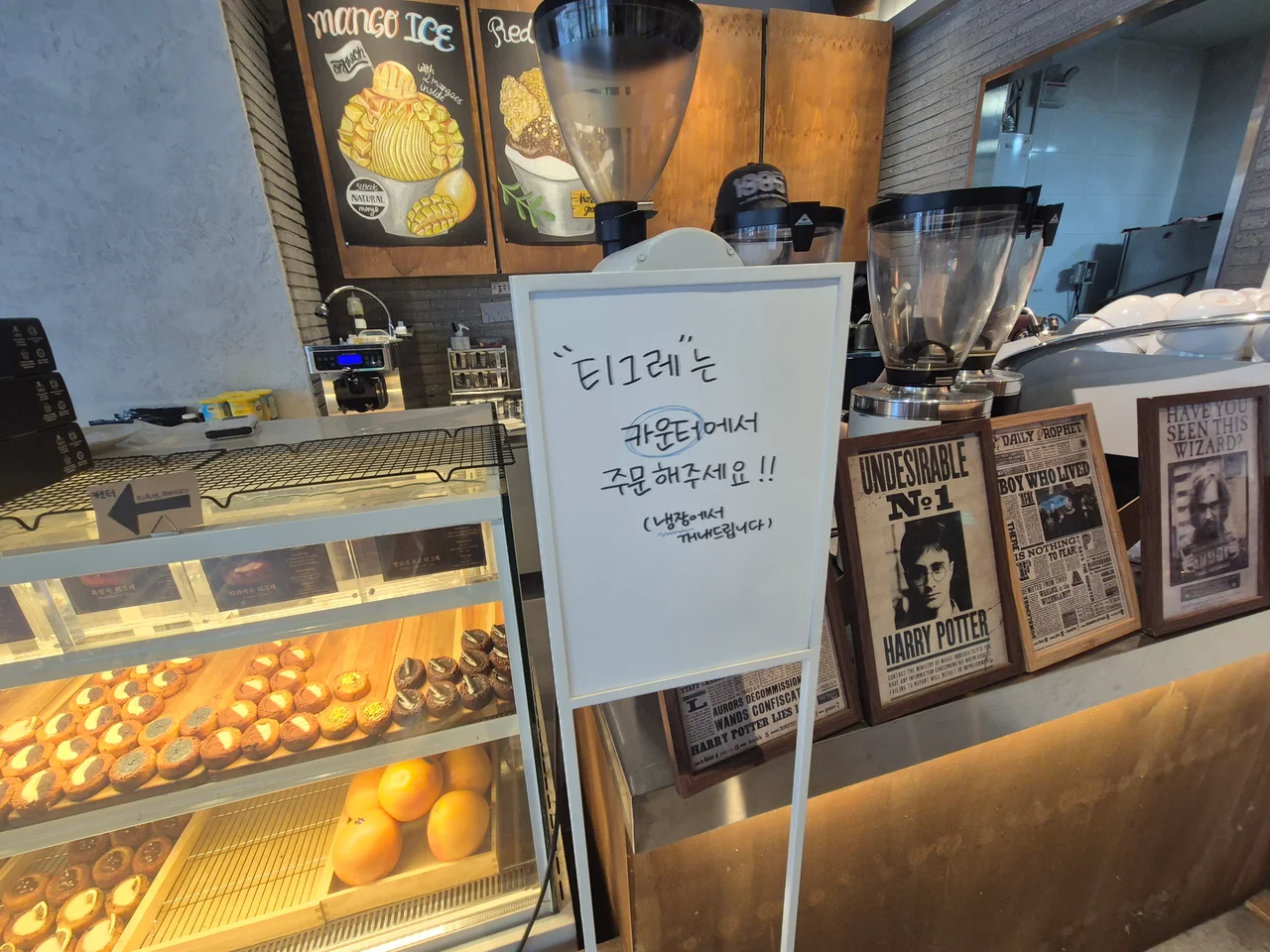 티그레 카운터 주문 안내판과 해리포터 포스터 소품