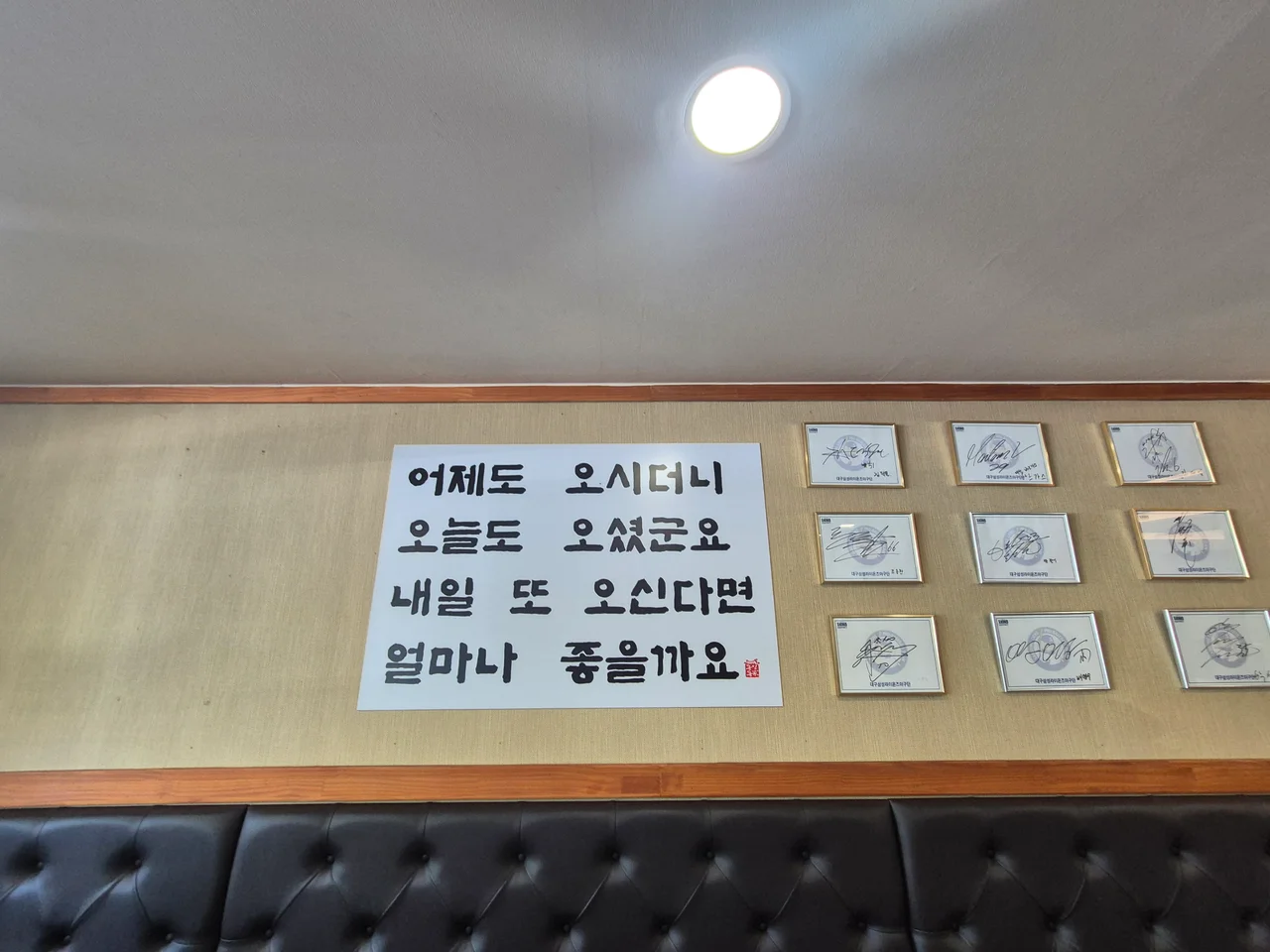 식당 내부 벽면에 붙은 재치 있는 문구와 액자들