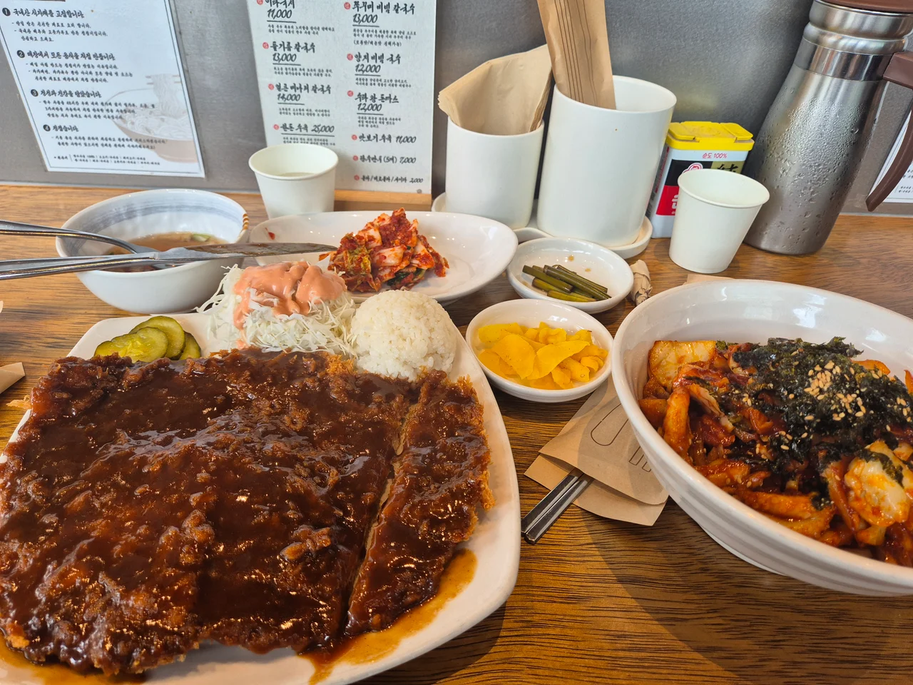 수타 왕 돈가스와 비빔 칼국수가 함께 차려진 테이블