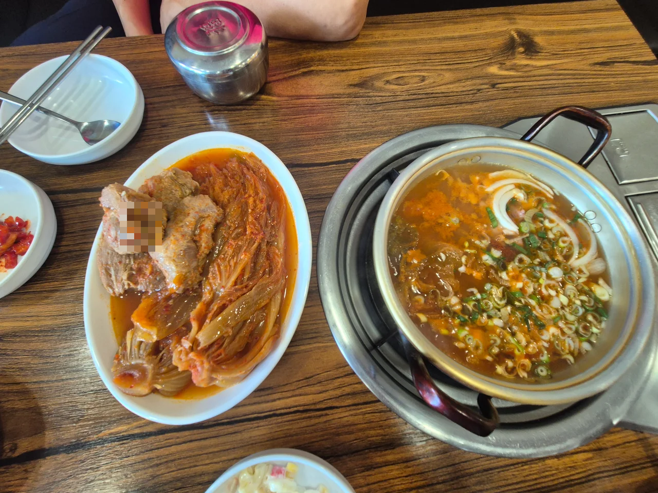 잘 삶아진 돼지고기와 김치가 담긴 하얀 접시