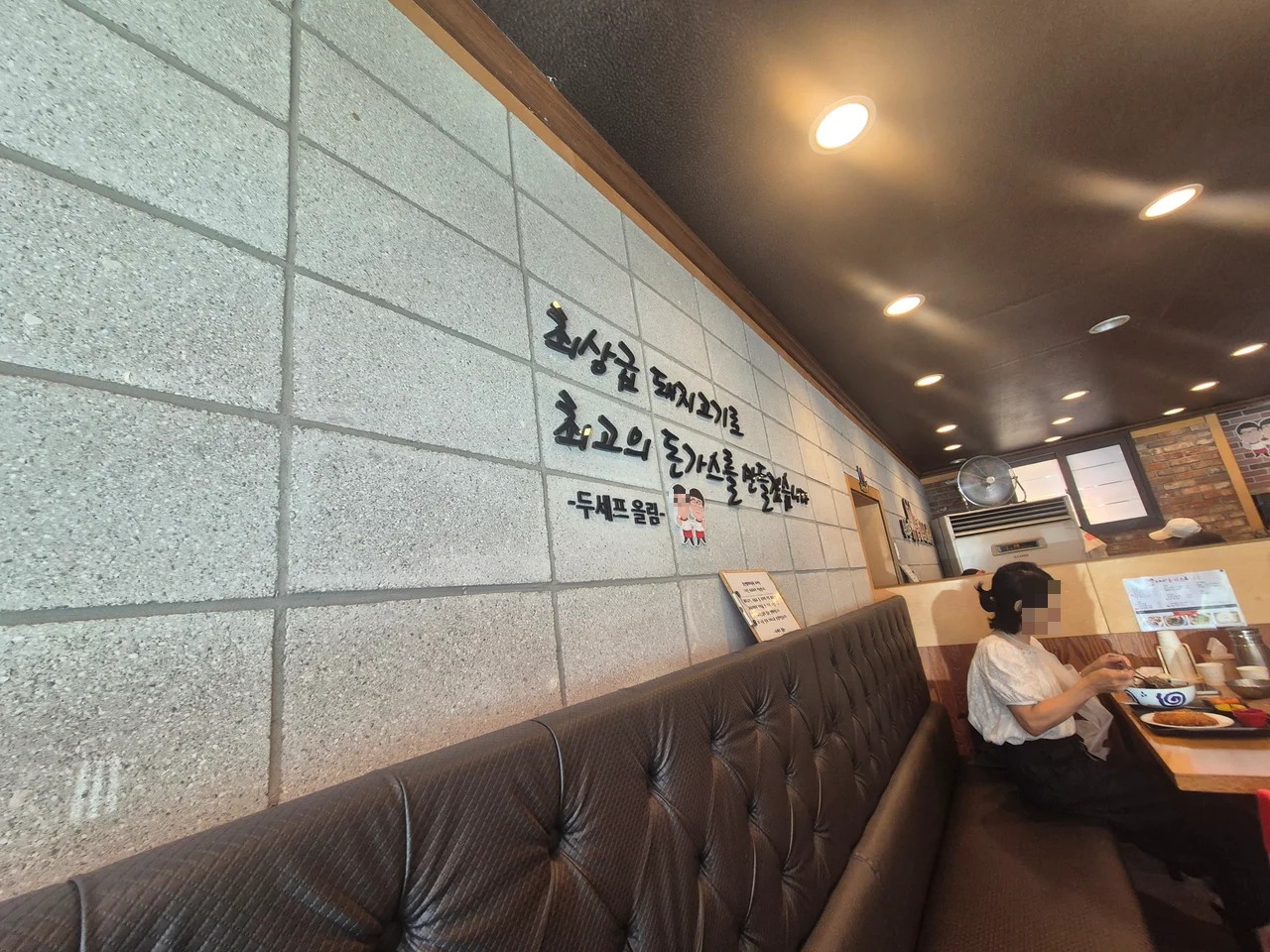 최상급 돼지고기로 최고의 돈까스를 만들겠다는 문구가 적힌 벽면